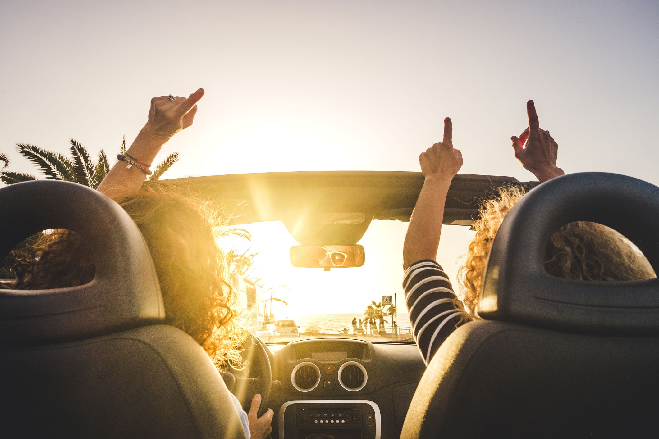 Couple driving in an open top car listening to music on the radio