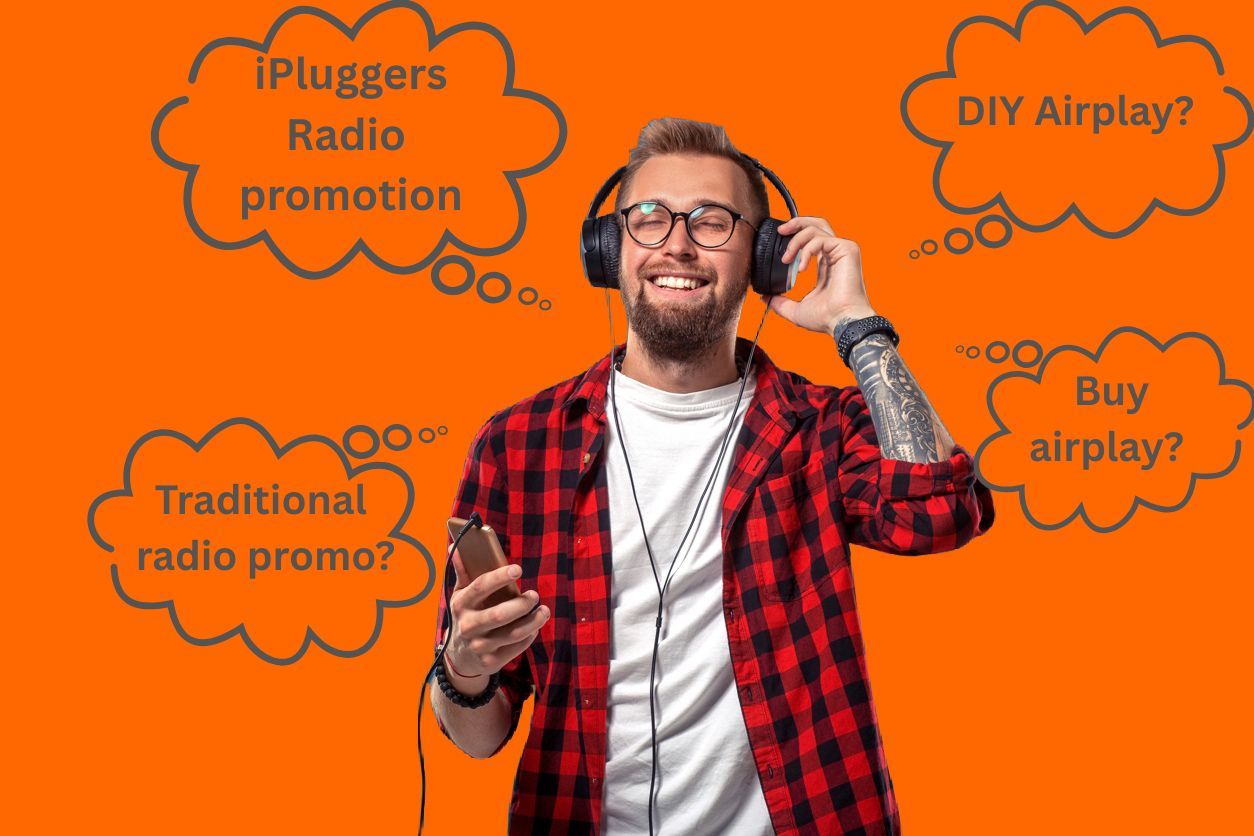 A male indie musician listens to music on headphones while thinking about how he can get radio airplay.