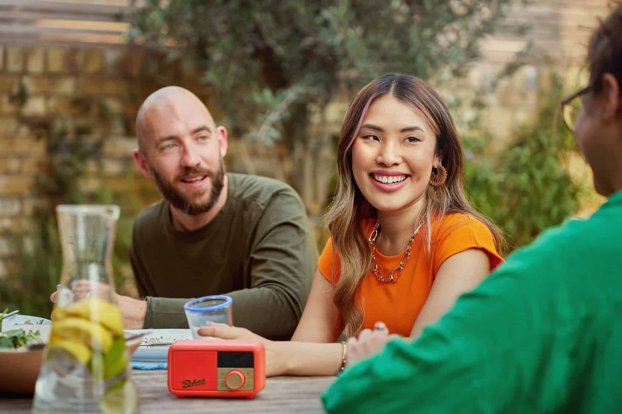Radio vs Streaming: How Independent Artists Can Get Their Music Heard Three friends sat at a picnic table outside listening to the radio.